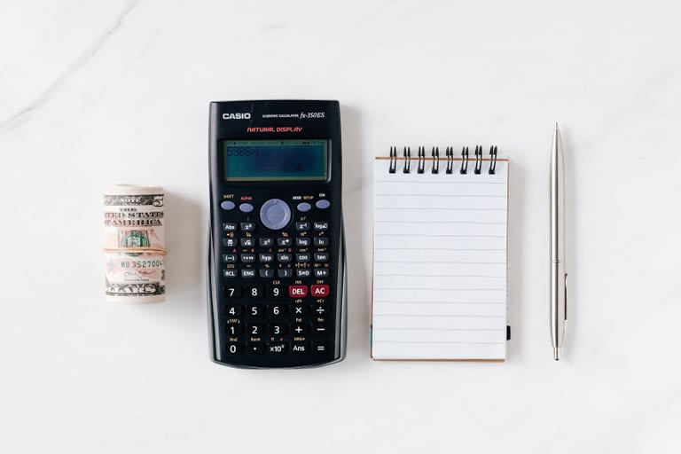 Money, calculator, and notepad on marble background